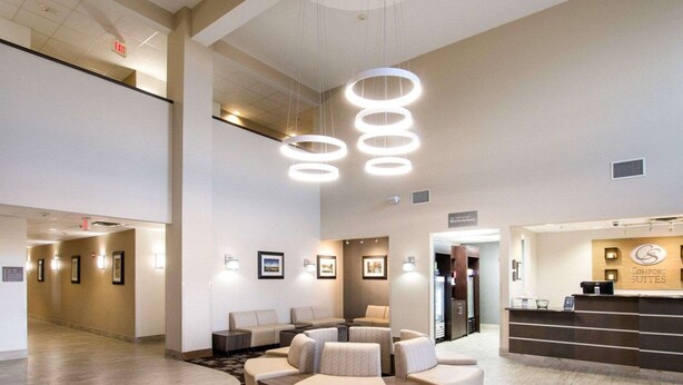 En hotellobby med en rund sittgrupp, en receptionsdisk och inramade tavlor på väggarna.