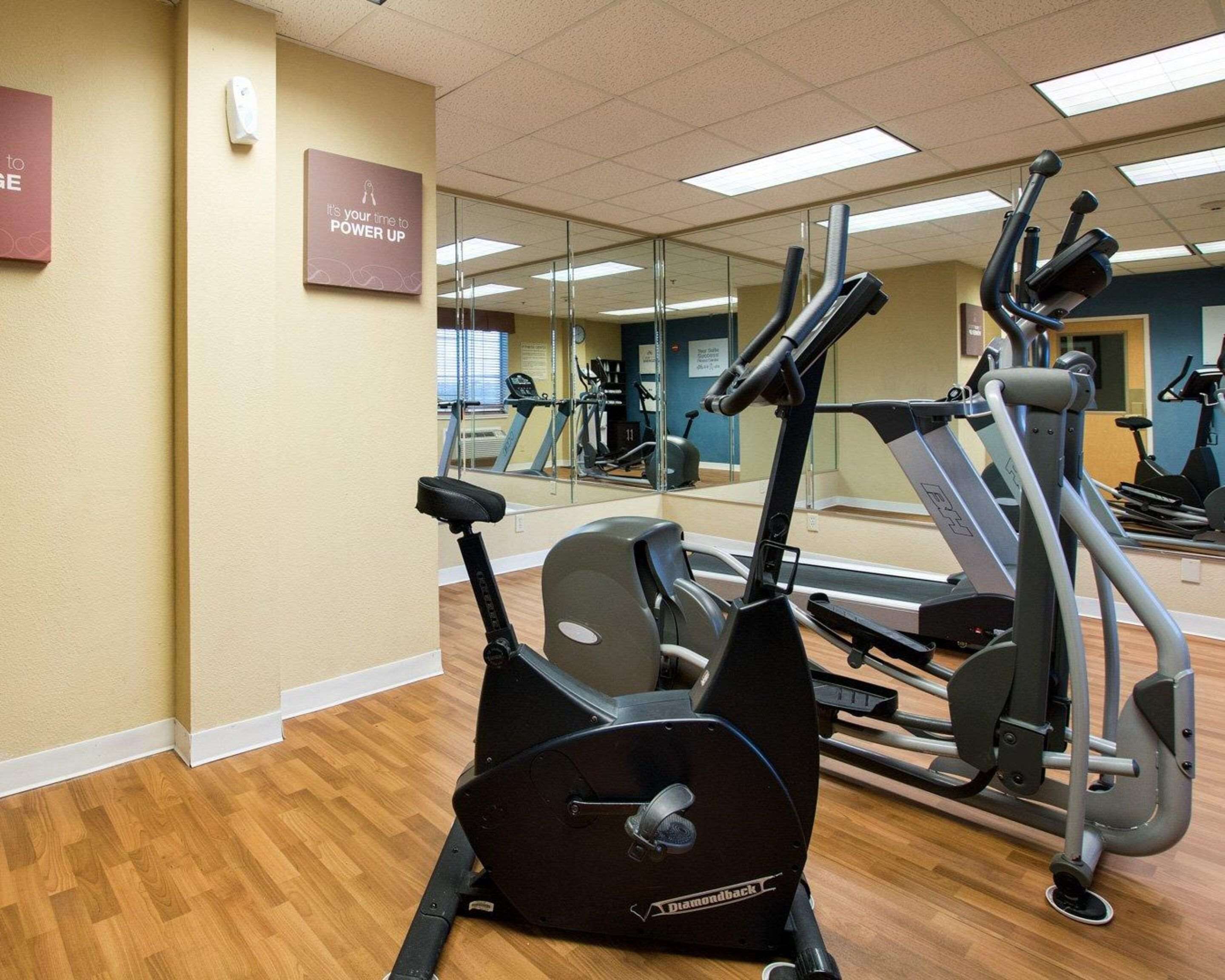 Ein Fitnessstudio mit Trainingsgeräten, darunter ein Laufband und ein Crosstrainer.