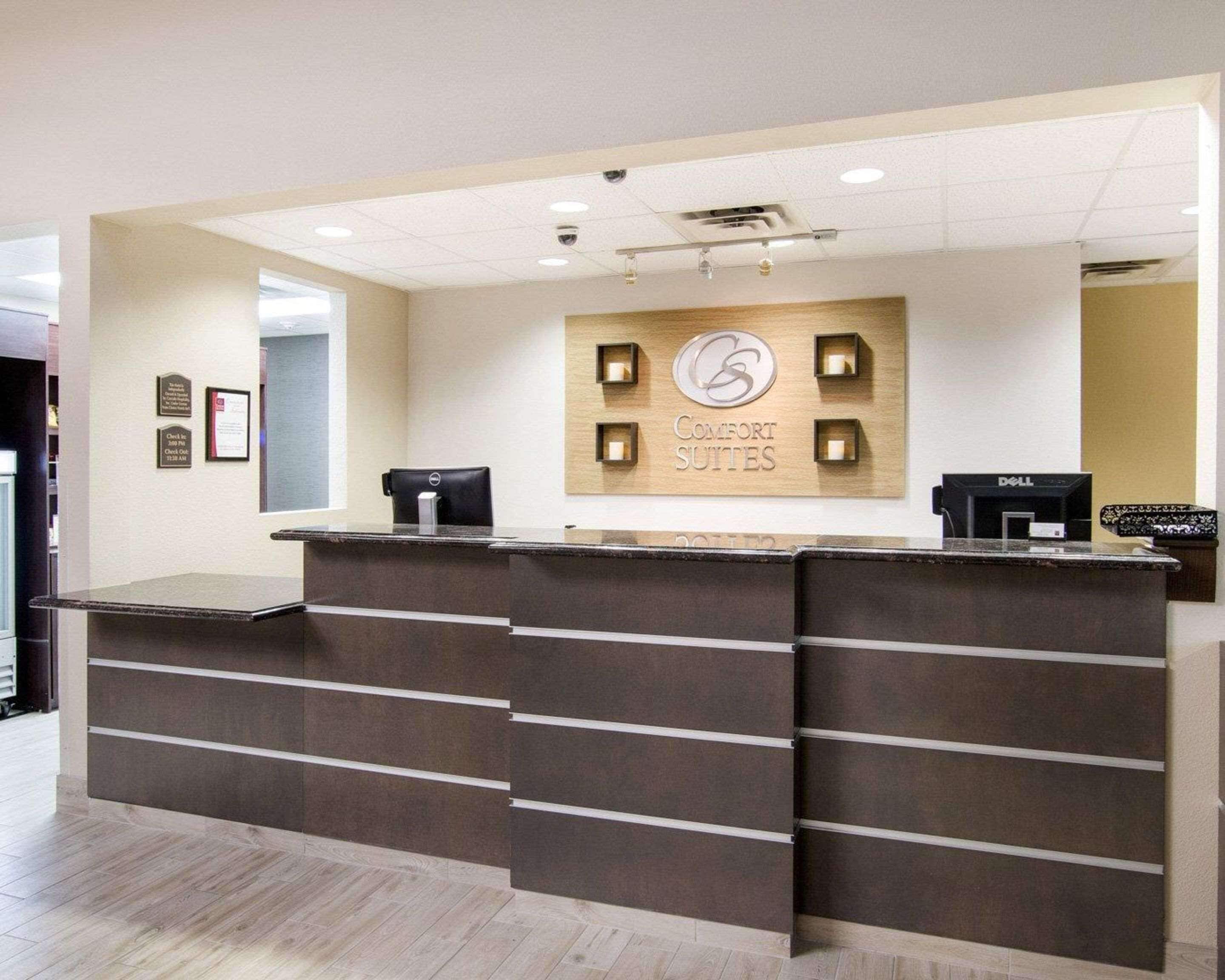 Una reception con una targa che riporta 'Comfort Suites' e un computer Dell.