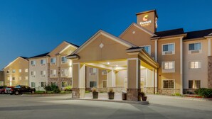 Un hôtel doté d’une entrée couverte, de plusieurs étages et d’une enseigne indiquant qu’il s’agit d’un hôtel de la chaîne Comfort Suites.