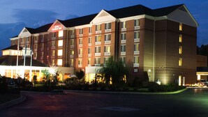 A multi-story hotel with a prominent entrance, a well-lit facade, and a parking area in front. - Hilton Garden Inn Anderson (Anderson)