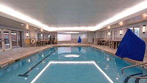 An indoor swimming pool with clear lane markings, a lifeguard chair, and a blue towel on the right side. - Homewood Suites by Hilton Albany (Albany)