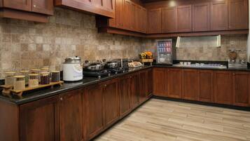 A kitchen with wooden cabinets, a granite countertop, a built-in oven, and a coffee maker.