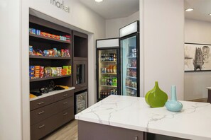 A kitchen with a marble countertop, a refrigerator, and a pantry stocked with food items. - Residence Inn by Marriott Columbia (Columbia)