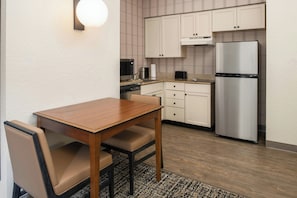A modern kitchen with a dining table, chairs, a microwave, a coffee maker, and a refrigerator. - Residence Inn by Marriott Columbia (Columbia)