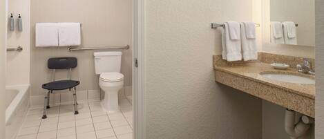 A bathroom with a toilet, bidet, and a small step stool.