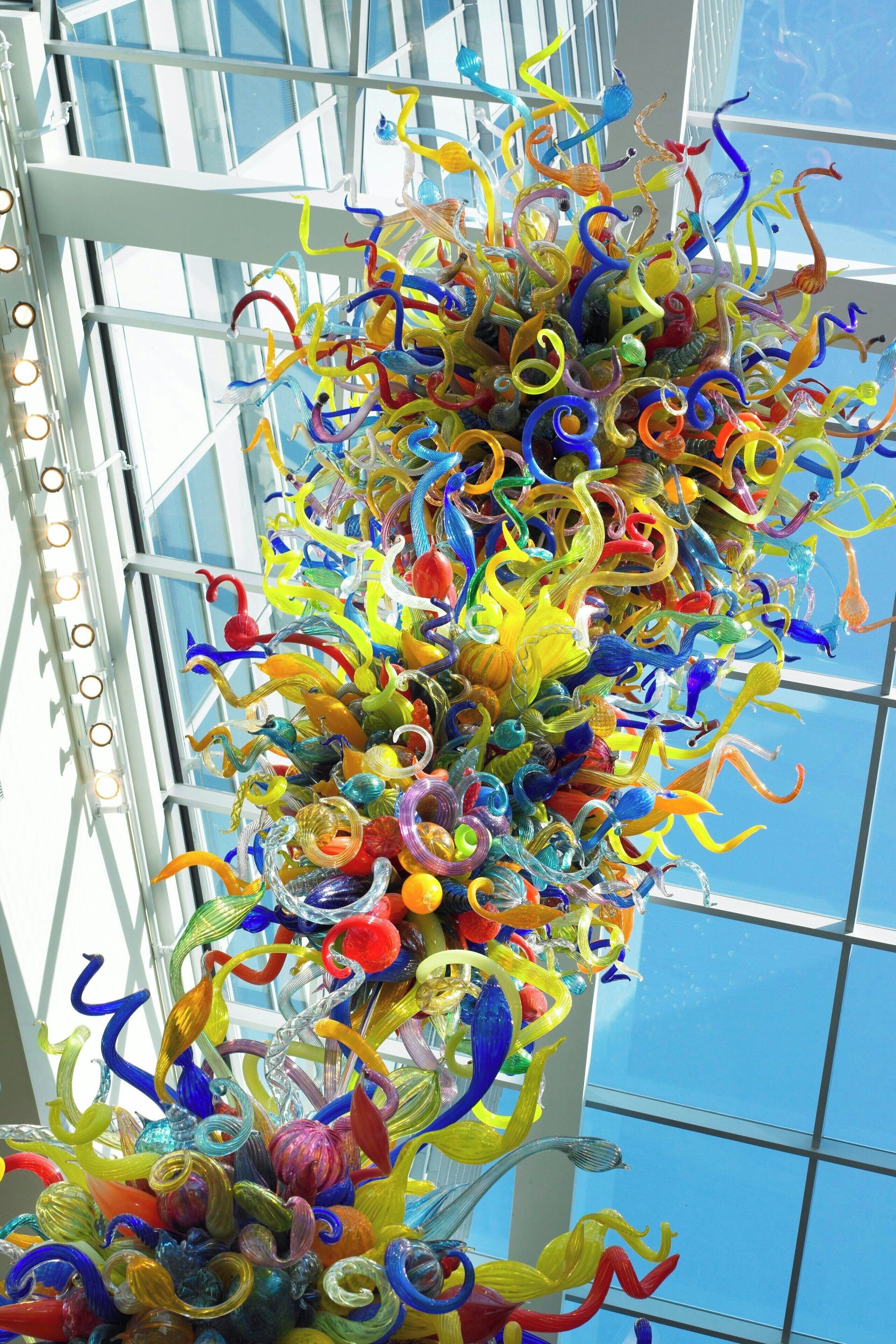 A colorful glass sculpture in a modern building with large windows.