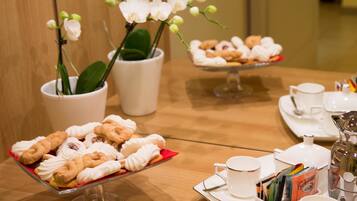 A buffet table with pastries and a coffee station.