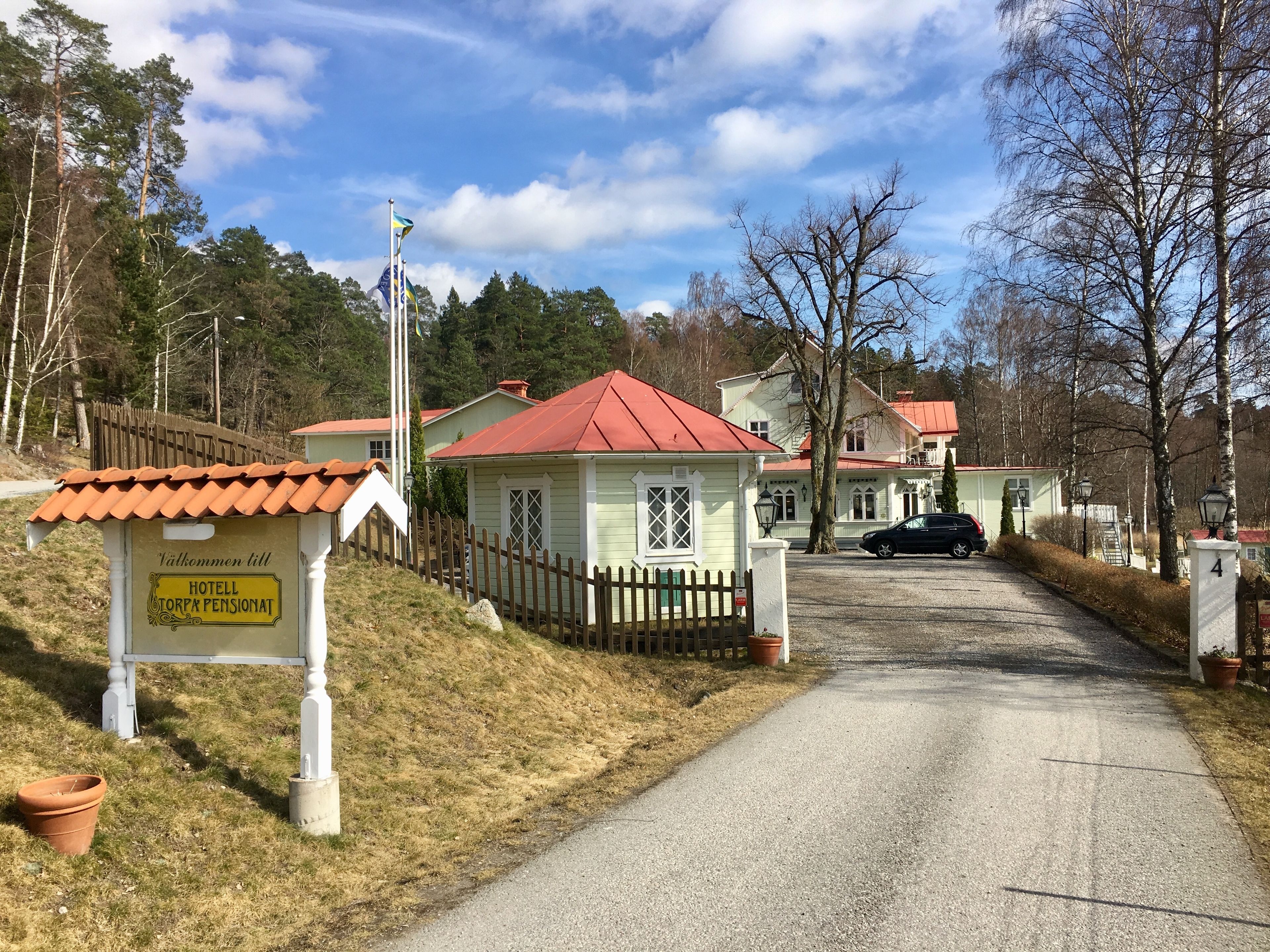 A rural hotel entrance with a sign indicating it is a pension.