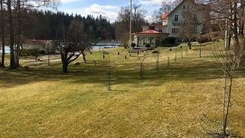 Ett grönområde med en byggnad i bakgrunden.