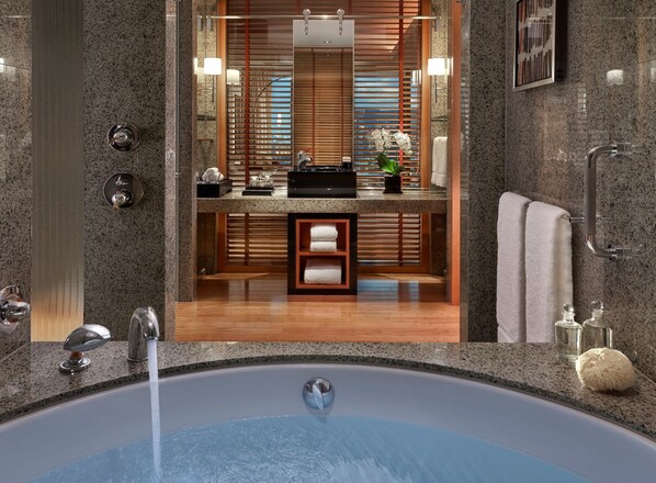 A modern bathroom with a granite countertop, a built-in sink, and a large mirror.