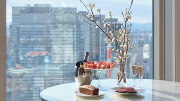 A table with a bottle of champagne, a vase with flowers, and plates with food.