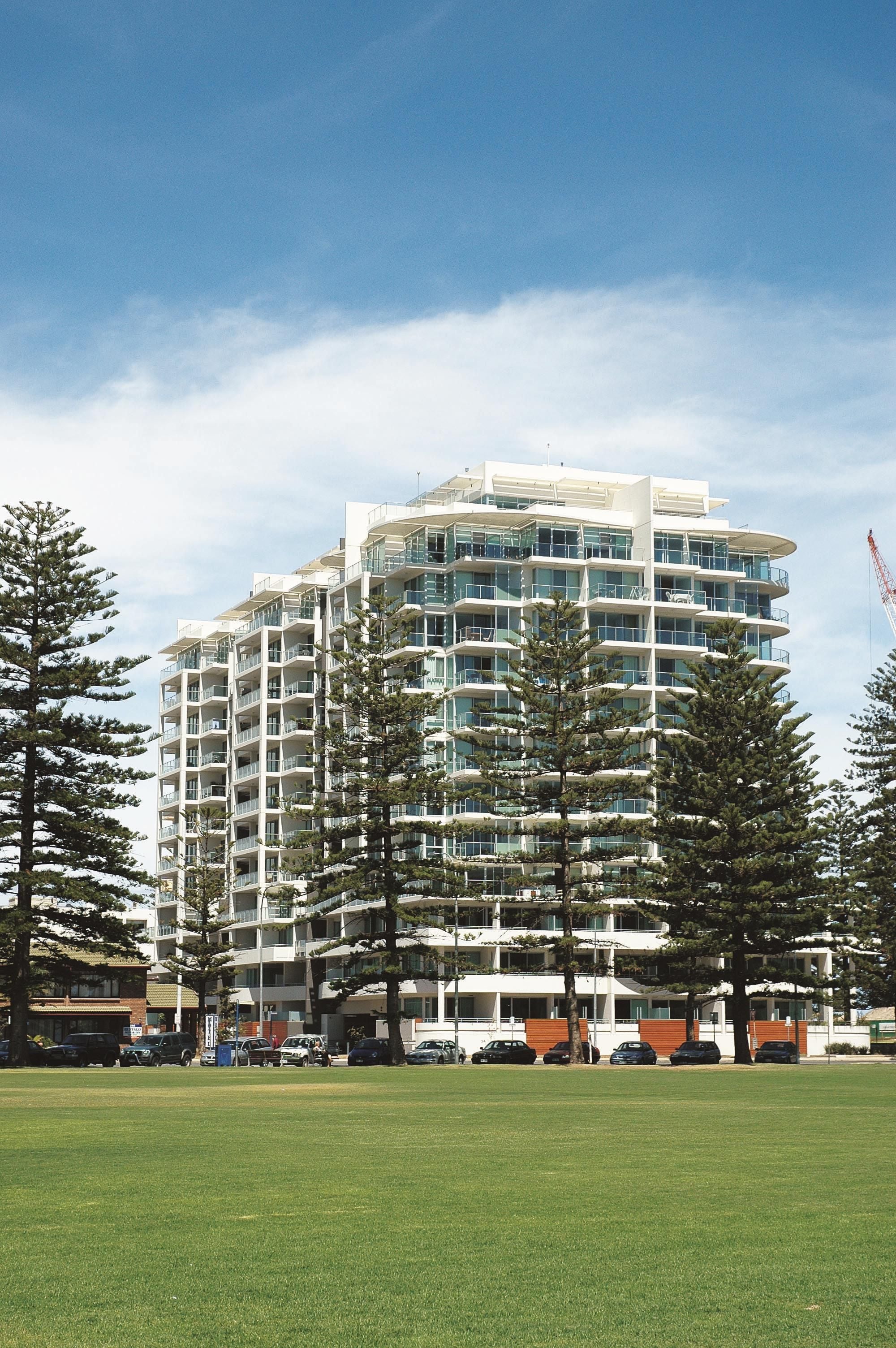 A multi-story hotel with a modern architectural design, featuring balconies and large windows.