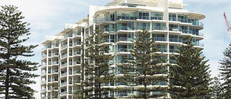 A multi-story hotel with a modern architectural design, featuring balconies and large windows.