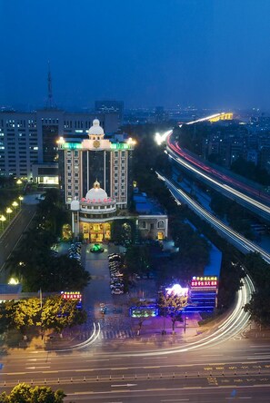 A multi-story building with a central dome and a series of lights along the top. - Wa King Town (Guangzhou)