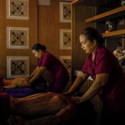A massage therapy room with wooden walls and shelves containing various items.