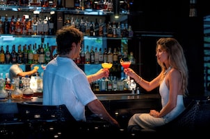 A bar setting with a bartender and a customer.