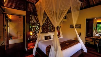 A room with a bed under a canopy, a desk with a chair, and a window with a view.