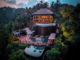 Ein Resort mit Pool, Außensitzgelegenheiten und Restaurant auf einem Hügel.