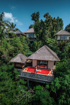 Un resort tropical con bungalows de techo de paja rodeados de exuberante vegetación.