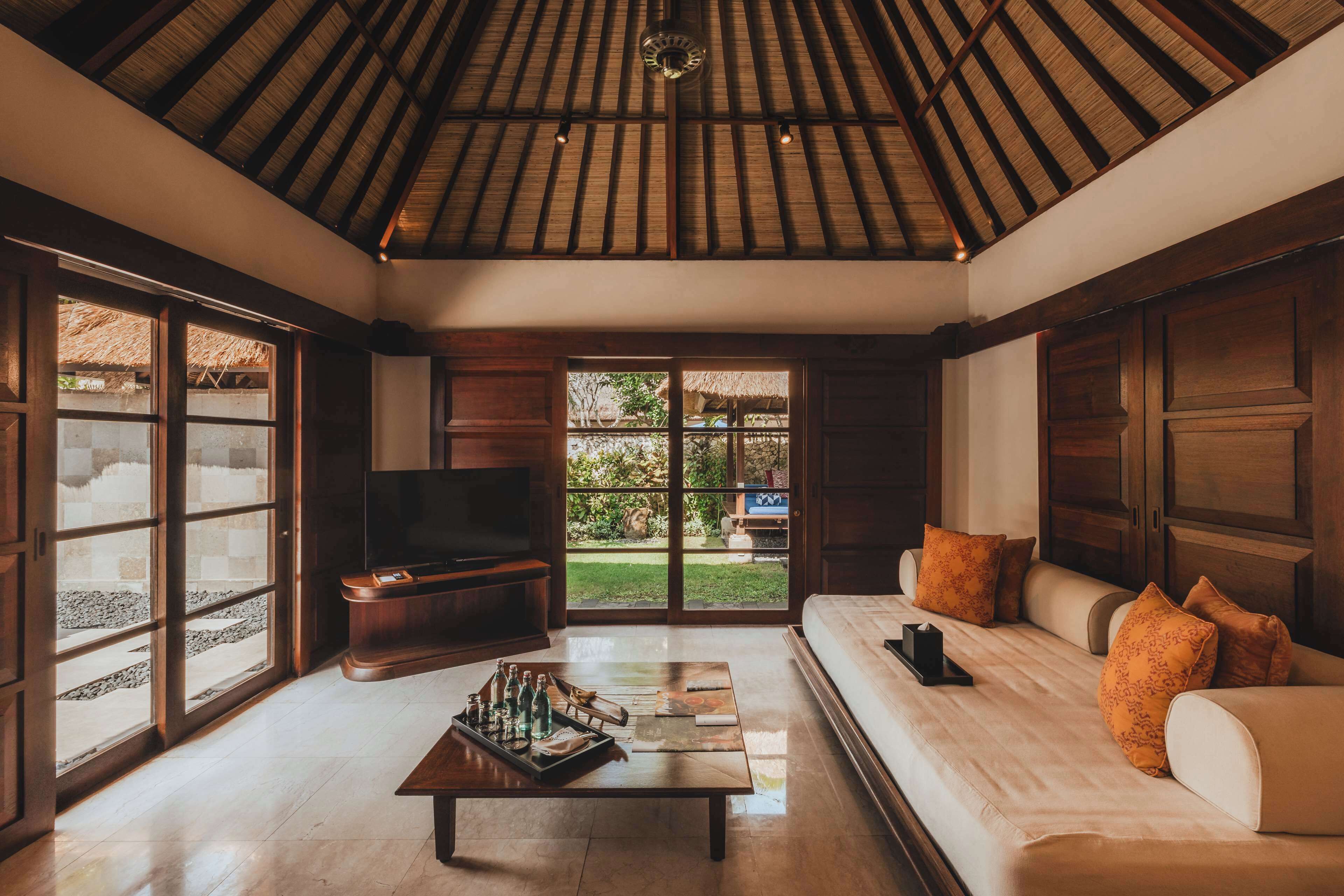 Amplia sala de estar con techo alto, ventanas grandes, un conjunto de sofás y una mesa de centro.