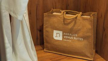 Una bossa de paper marró amb la inscripció 'PARALOS VENUS SUITES' sobre una superfície de fusta.