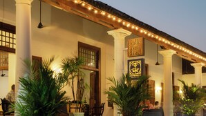 A hotel exterior with columns, string lights, and potted plants. - Galle Fort Hotel (Galle)
