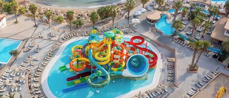 A resort with a large water park, multiple pools, and beach areas with sun loungers.