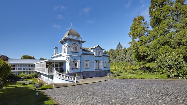 Un grand bâtiment blanc à deux étages, doté d’une tour et d’un porche couvert.