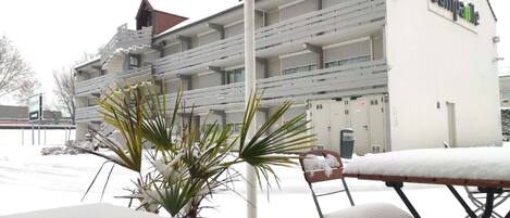 A hotel with a white exterior, multiple balconies, and a sign reading "Campol".
