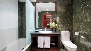 Un baño moderno con cabina de ducha de vidrio, un lavabo blanco y un inodoro.