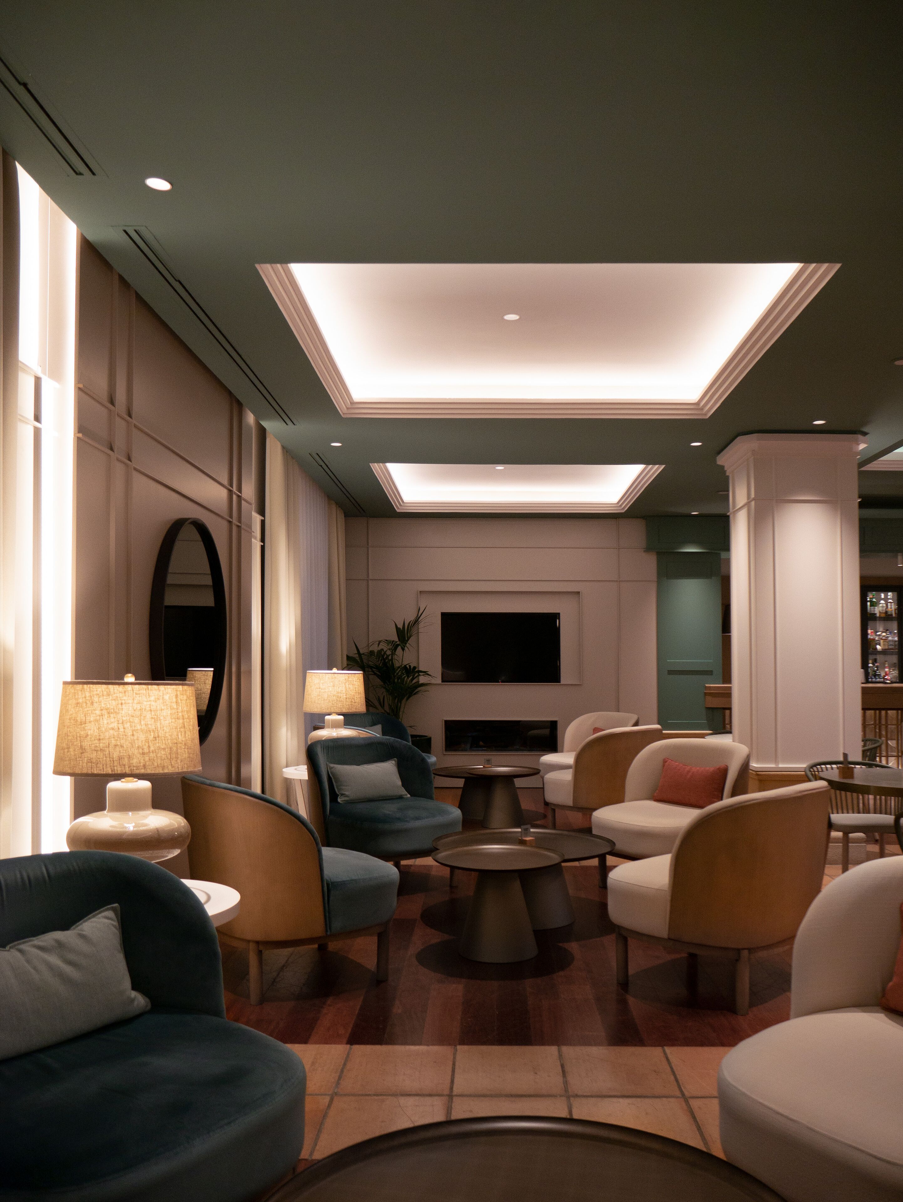 Una sala de estar moderna con sofás, sillones y un televisor de pantalla plana.