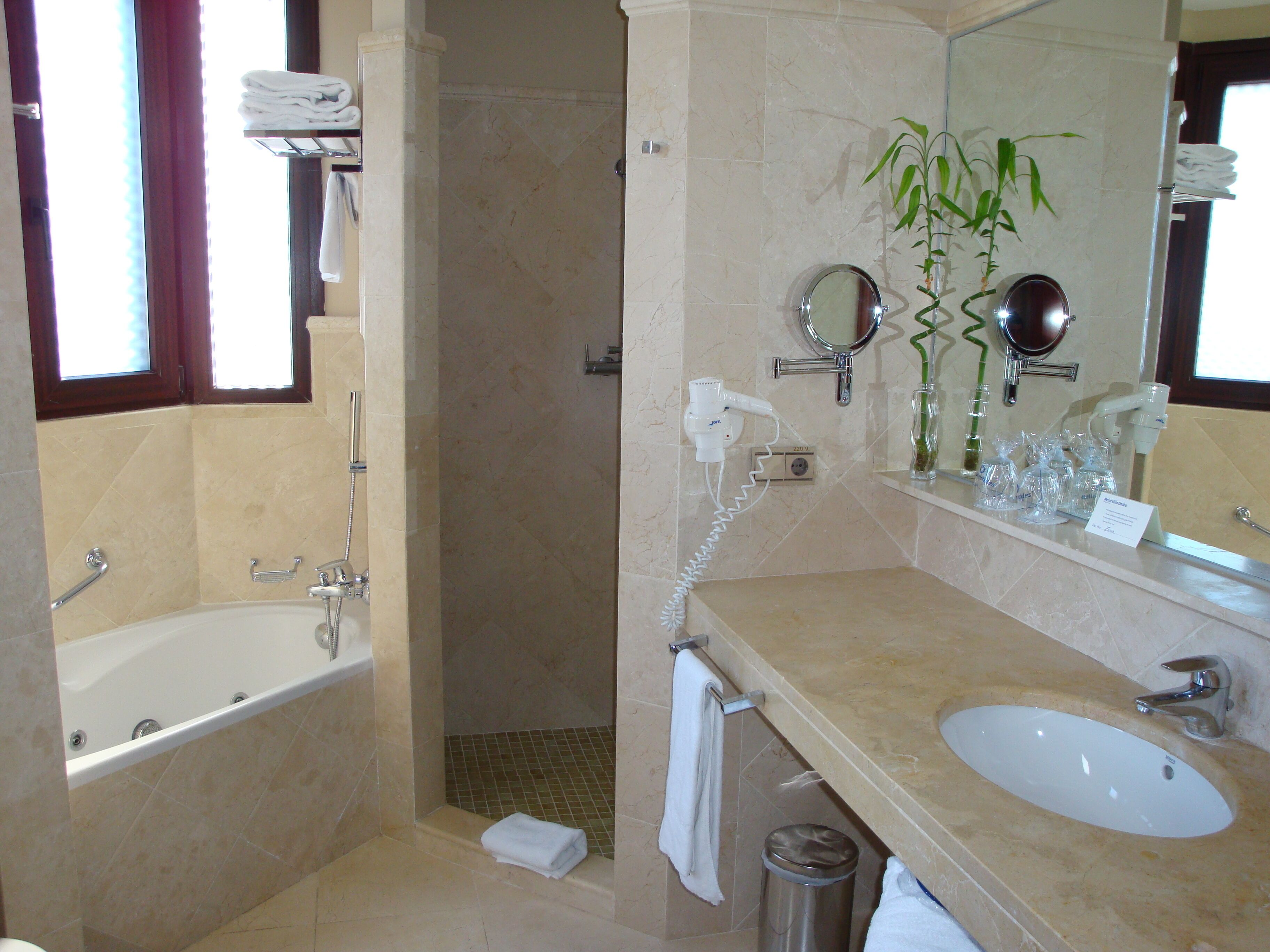 Ein Badezimmer mit Badewanne, Waschbecken, Spiegel und Dusche.