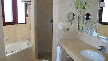 A bathroom with a bathtub, a sink, a mirror, and a shower.