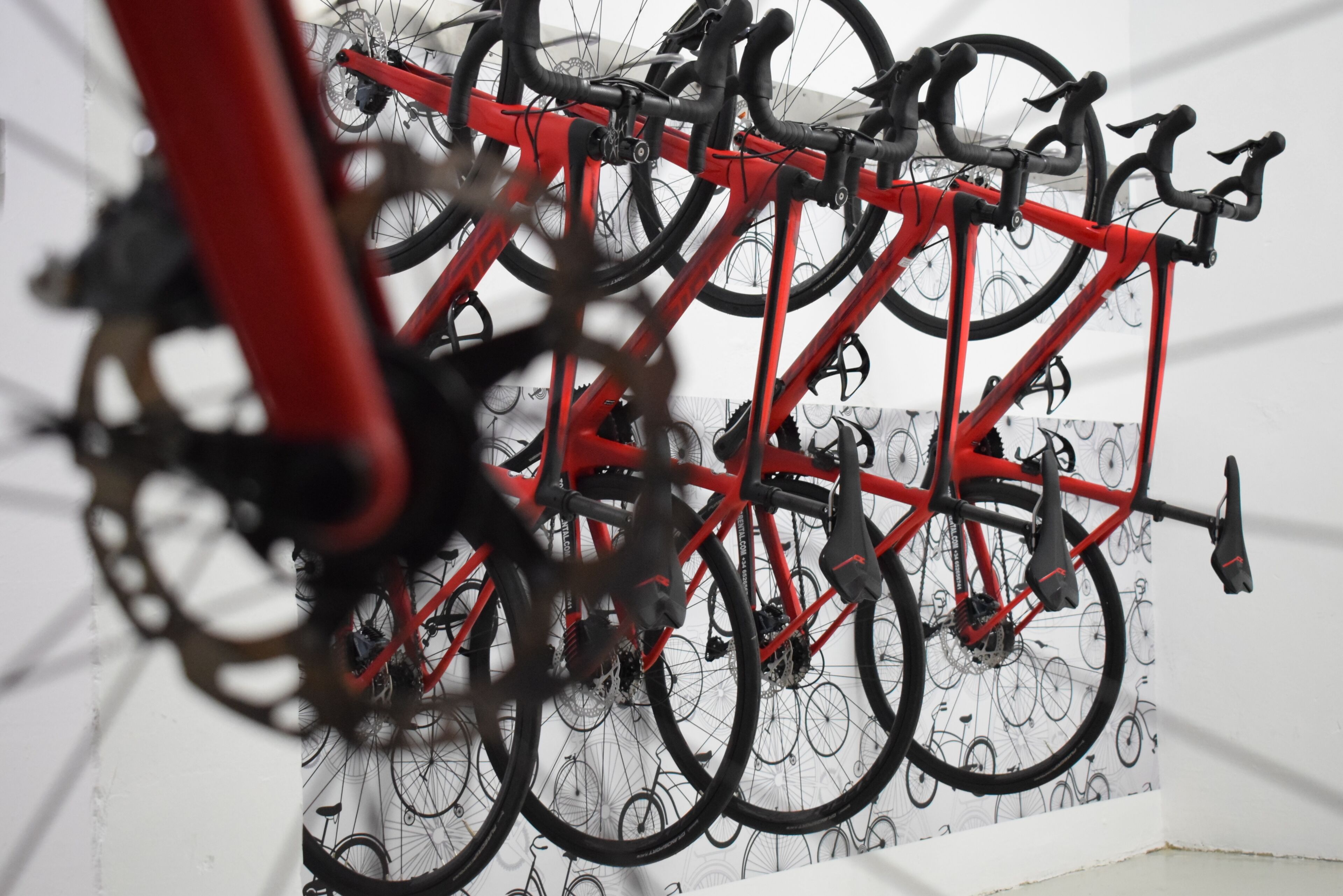 Un porte-vélos rouge sur lequel sont garés plusieurs vélos.