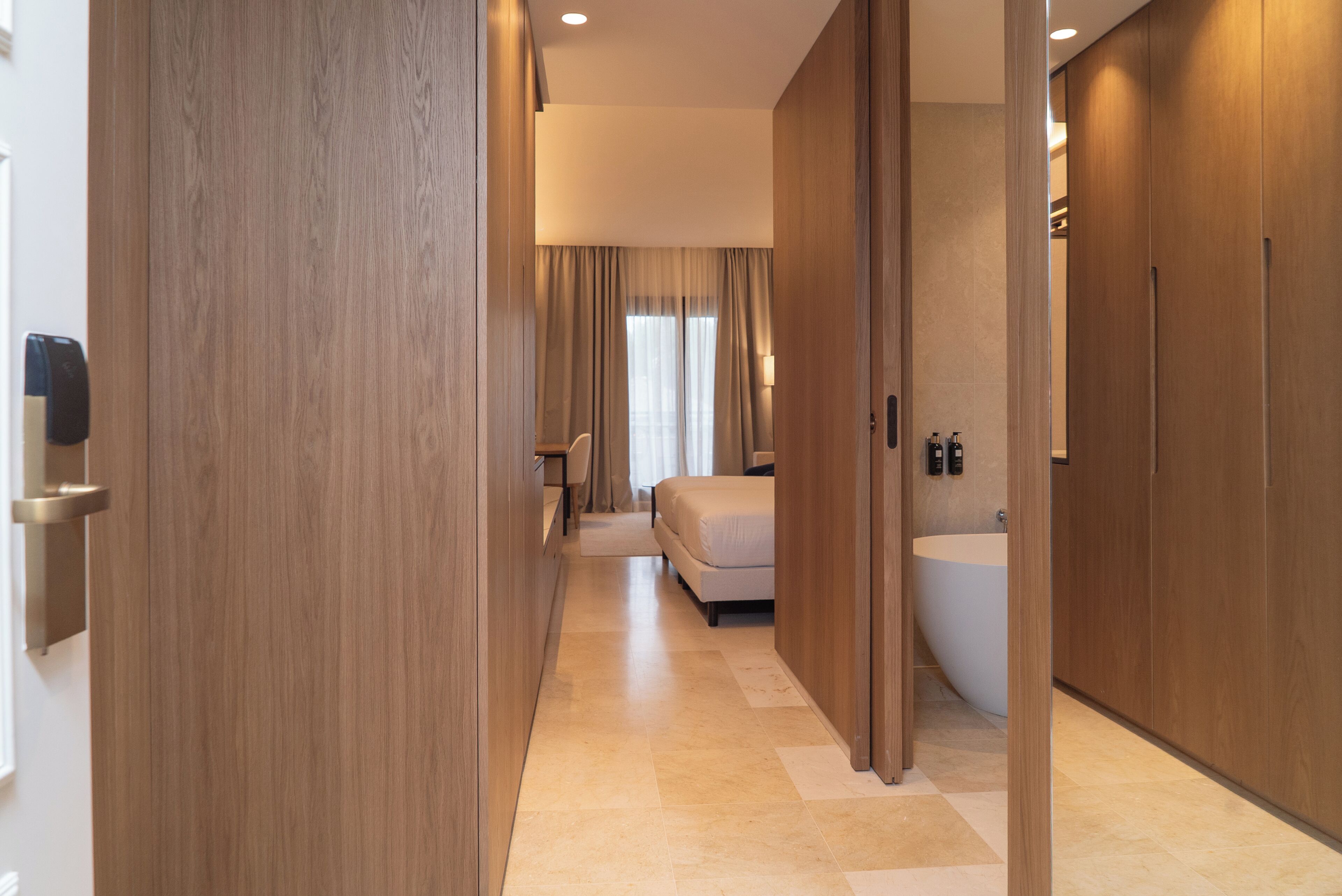 A hotel room with a large bathtub, a bed, and a desk.