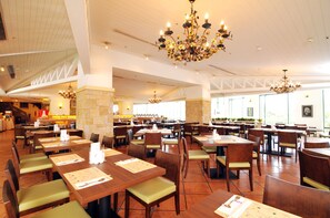 A spacious restaurant with multiple dining tables and chairs, large chandeliers, and a high ceiling. - Yangmingshan Tien Lai Resort & Spa (New Taipei City)