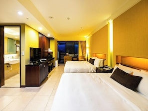 A hotel room with two beds, a desk with a TV, and a bathroom visible through an open door. - Yangmingshan Tien Lai Resort & Spa (New Taipei City)