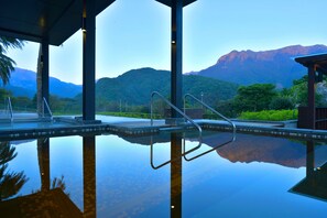 A pool with clear water reflecting the surrounding landscape, including mountains and greenery. - Yangmingshan Tien Lai Resort & Spa (New Taipei City)