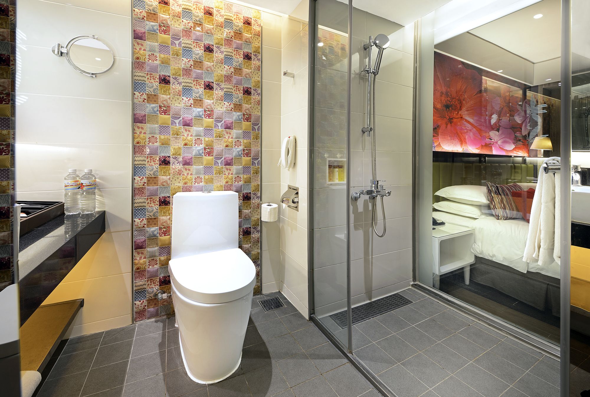 A modern bathroom with a toilet, shower, and a glass-enclosed shower area.