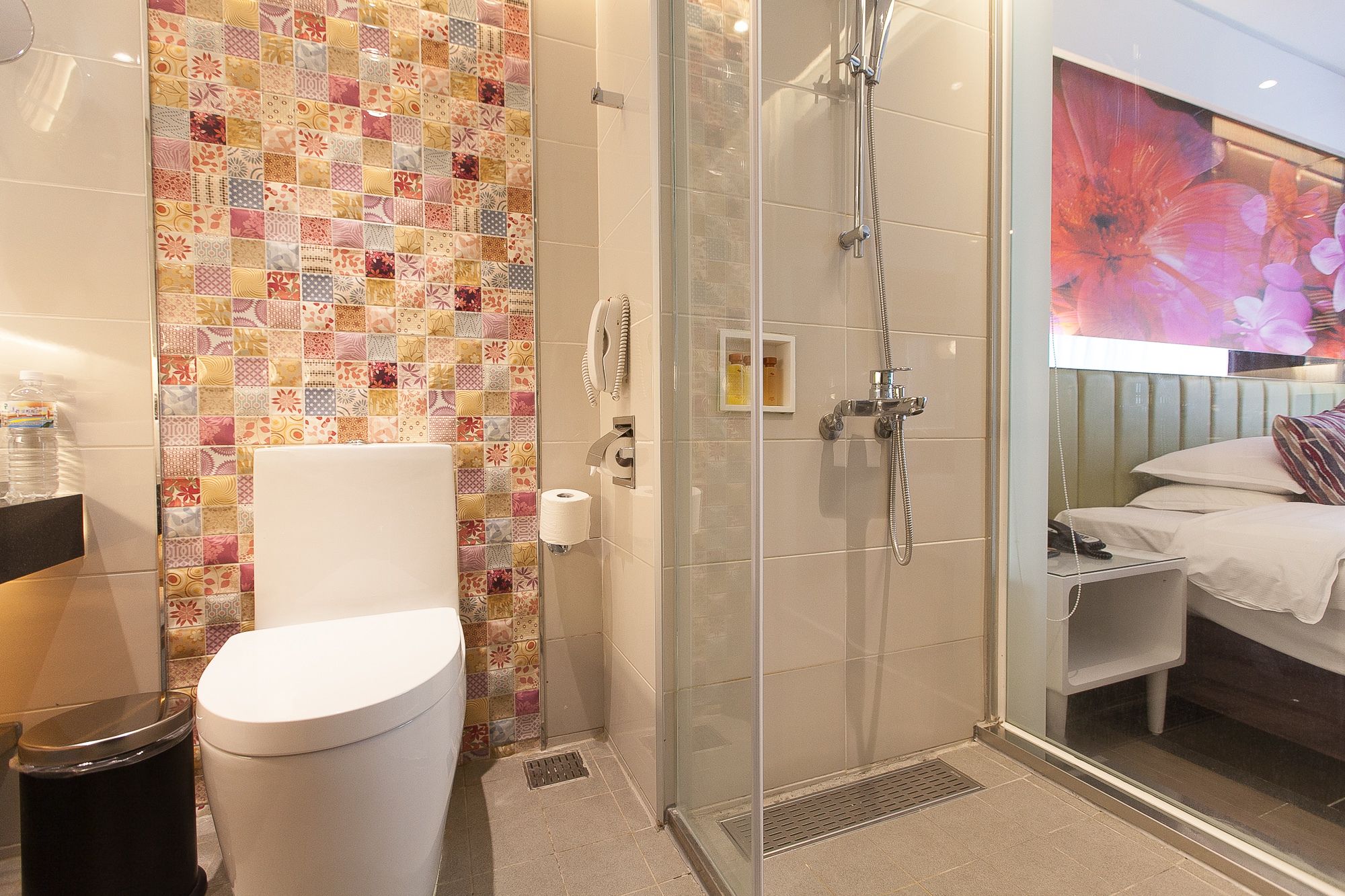 A bathroom with a glass-enclosed shower, a toilet, and a sink.