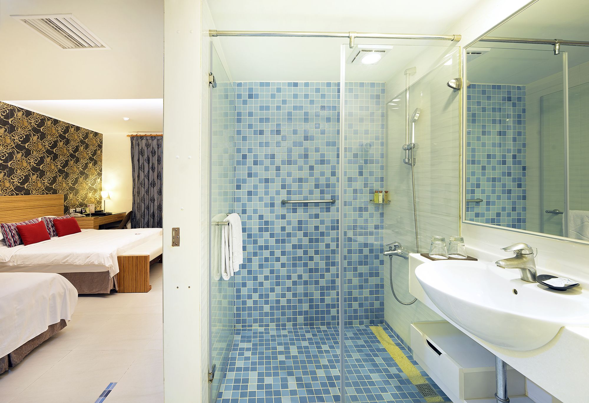 Een moderne badkamer met een douchecabine van glas, een witte wastafel en een grote spiegel.
