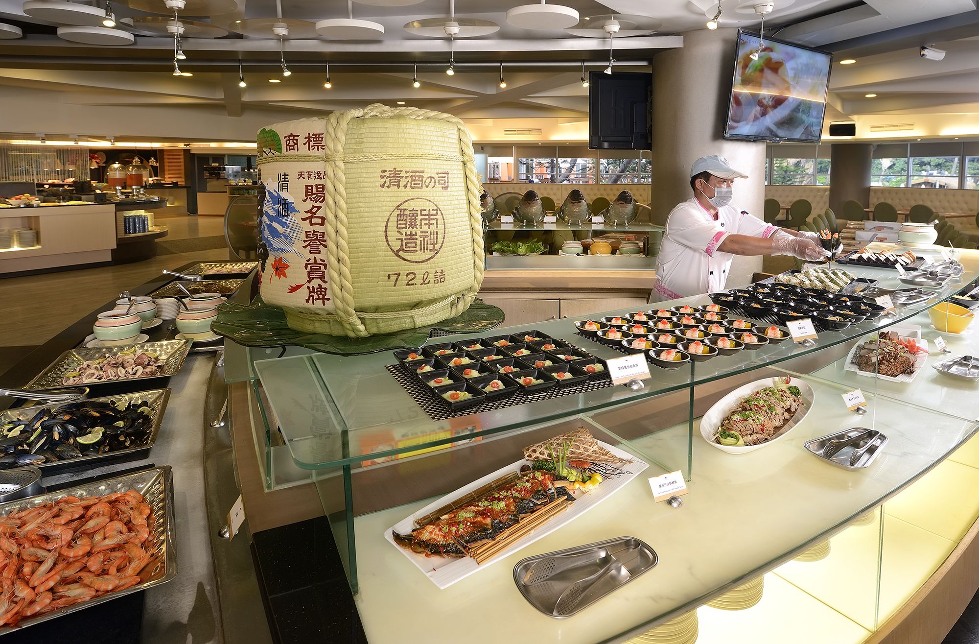 Un bufé con diversos platos, incluyendo mariscos y sushi, y una bolsa decorativa grande con texto.