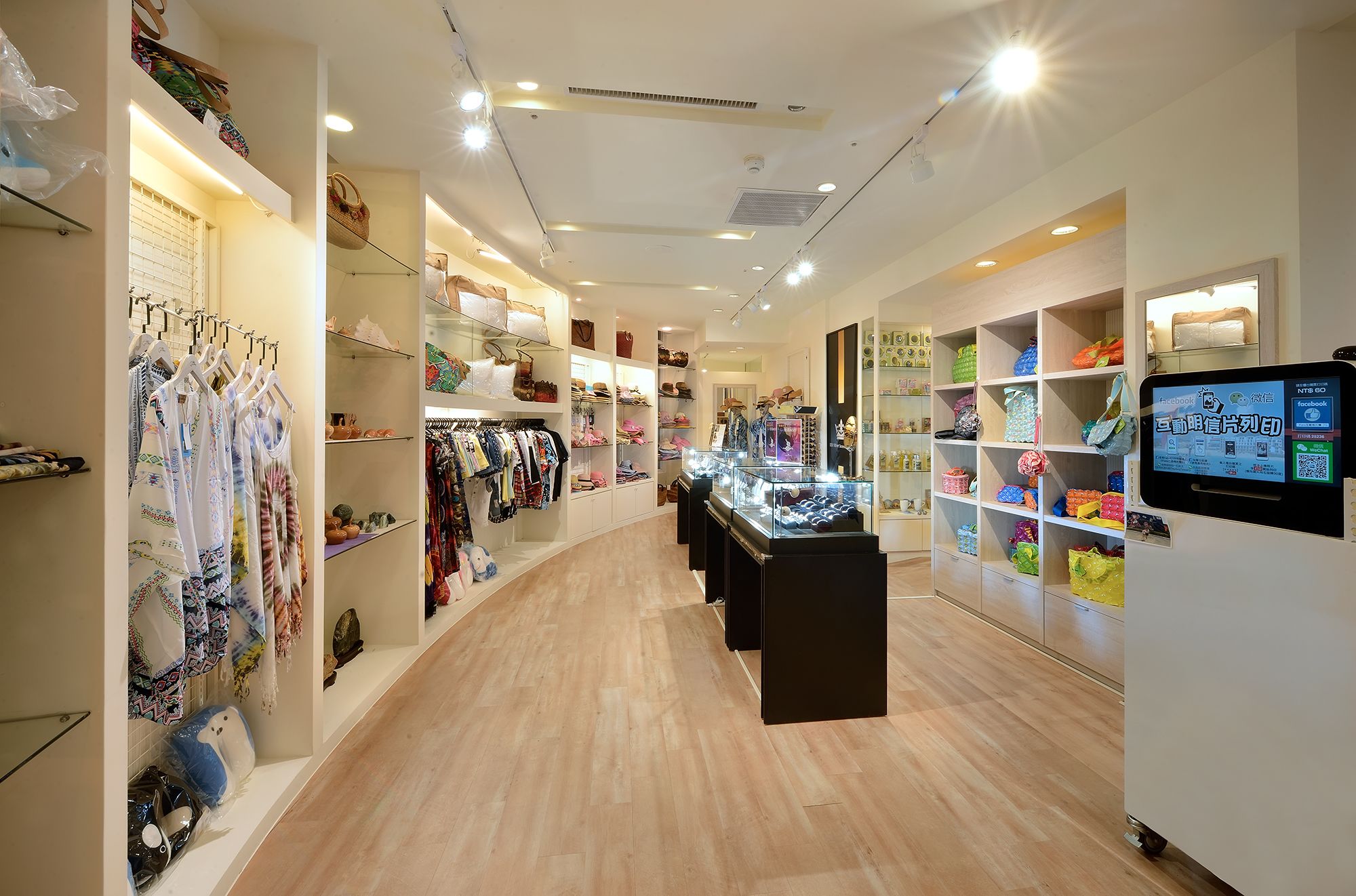 A well-lit retail store with shelves of handbags, clothing, and accessories.