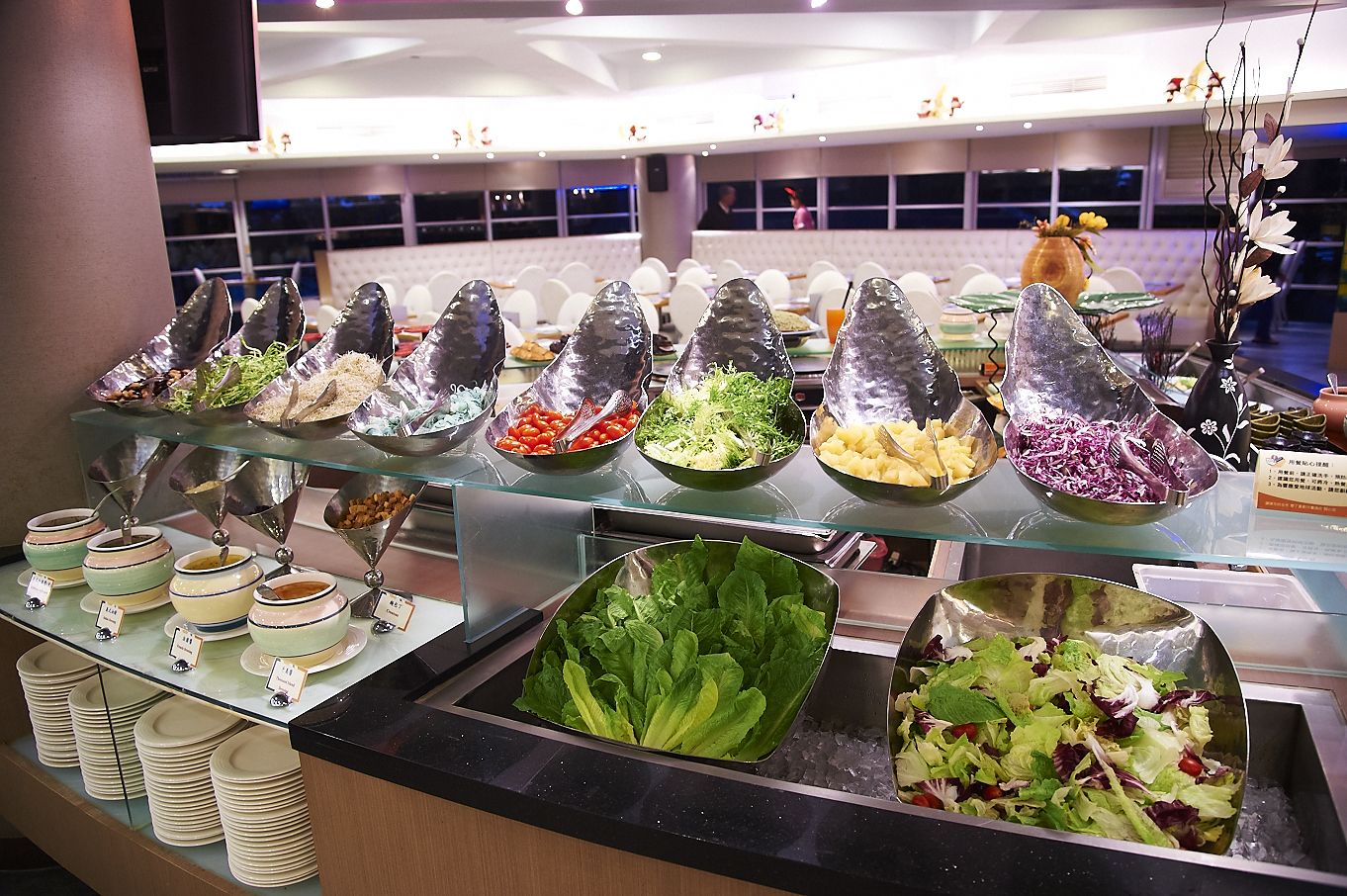 Un bufé con diversas opciones de comida, incluyendo ensaladas, frutas y verduras.
