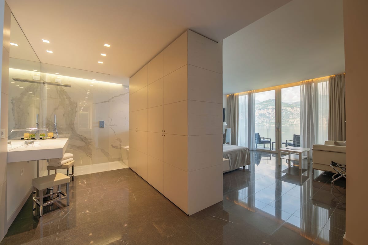 Une chambre d’hôtel moderne dotée d’une salle de bain, d’un coin salon et offrant une vue sur les montagnes.