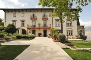 Stately building with a traditional European facade, surrounded by lush greenery and a tranquil atmosphere.