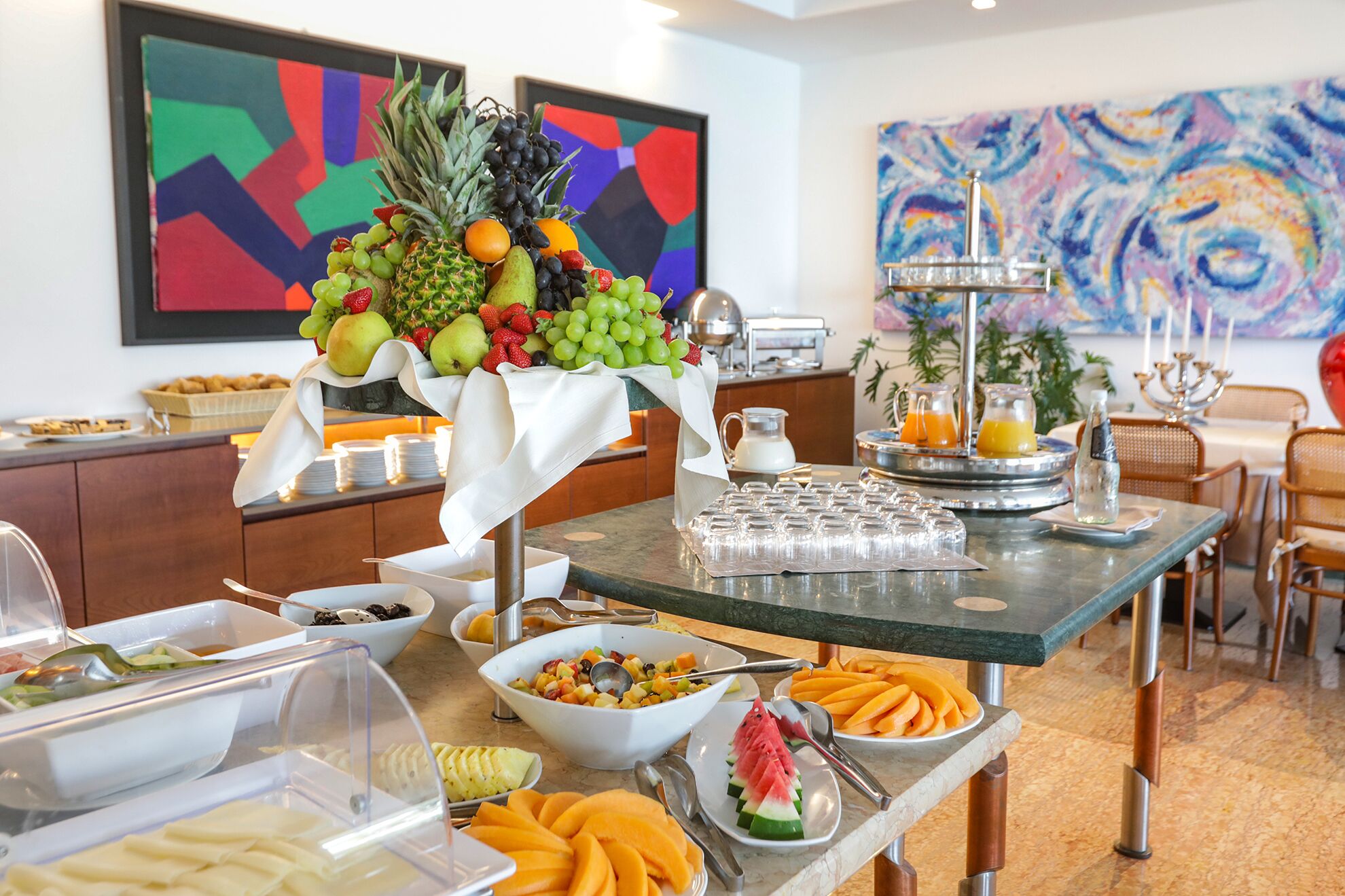 Un buffet de petit-déjeuner proposant une variété de fruits, de viennoiseries et de boissons.