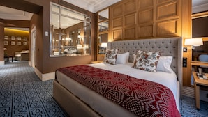 A spacious hotel room with a large bed, a wooden headboard, a large mirror, and a view of the hallway. - Hotel Rector (Salamanca)