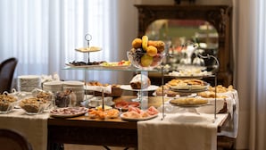 A buffet table with various food items and a glass display case. - Hotel Rector (Salamanca)